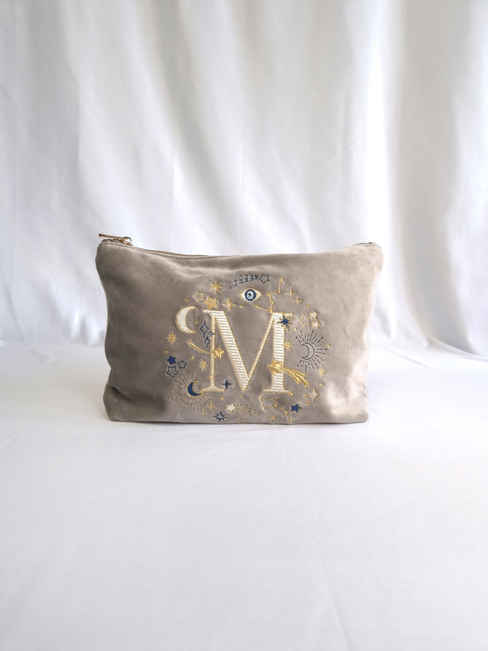 Beige Moonstone velvet pouch with gold and blue moon, stars, and evil eye embroidery, part of the Ciel des Rêves collection by Edoaria, limited-edition prototype toiletry bag.