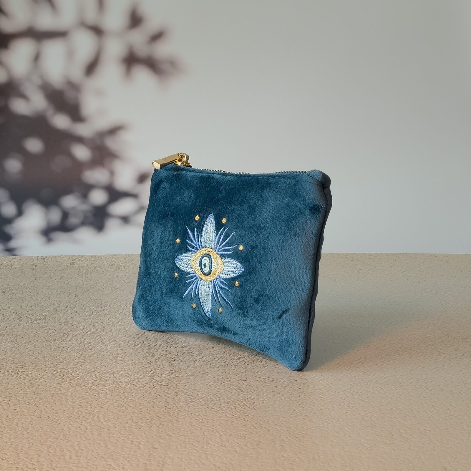 Side view of the Essentials Sleek Pouch highlighting its intricate floral embroidery with Mati protection.