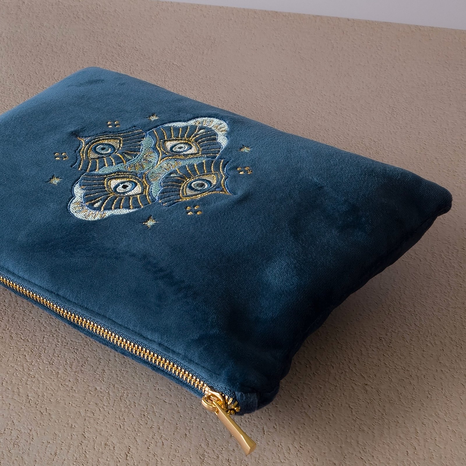 Essentials Sleek Pouch - Fermeture à glissière dorée et finition en velours de qualité supérieure A close-up of the gold zipper on the Essentials Sleek Pouch, with soft sapphire blue velvet.