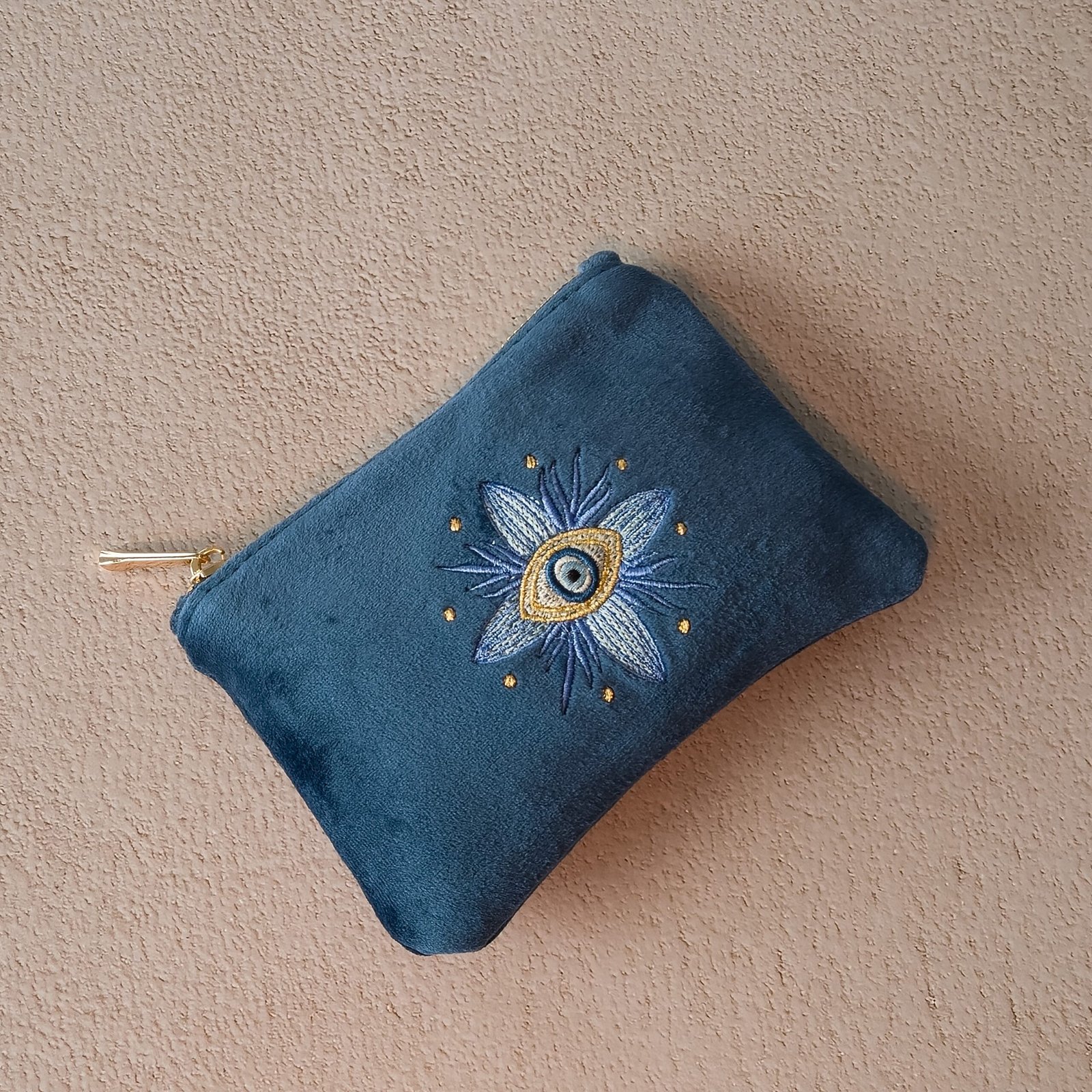 The Essentials Sleek Pouch laid flat, showcasing its delicate floral embroidery.