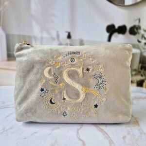 Beige Moonstone velvet pouch with gold and blue moon, stars, and evil eye embroidery, part of the Ciel des Rêves collection by Edoaria, limited-edition prototype toiletry bag. Letter "S"