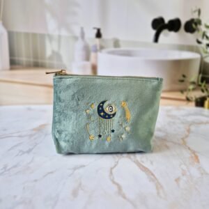 Front view of the Ciel des Rêves Petite Makeup Bag in Aqua Marine teal velvet, featuring moon, stars, and evil eye embroidery in blue, gold, and cream.