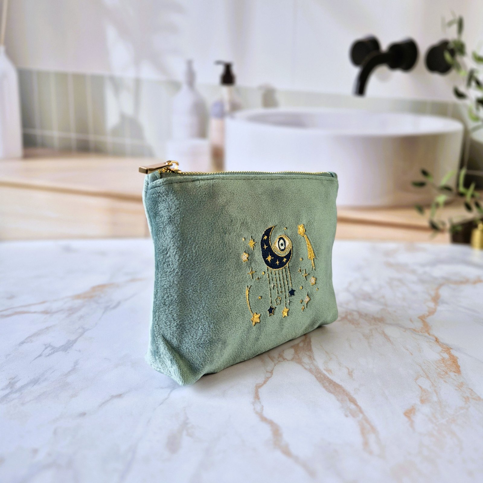 Vue en angle de la Petite Trousse de Maquillage Ciel des Rêves - Broderie Lune et Etoiles Angled view of the Ciel des Rêves Petite Makeup Bag in moonstone beige velvet with celestial embroidery in blue, gold, and cream.