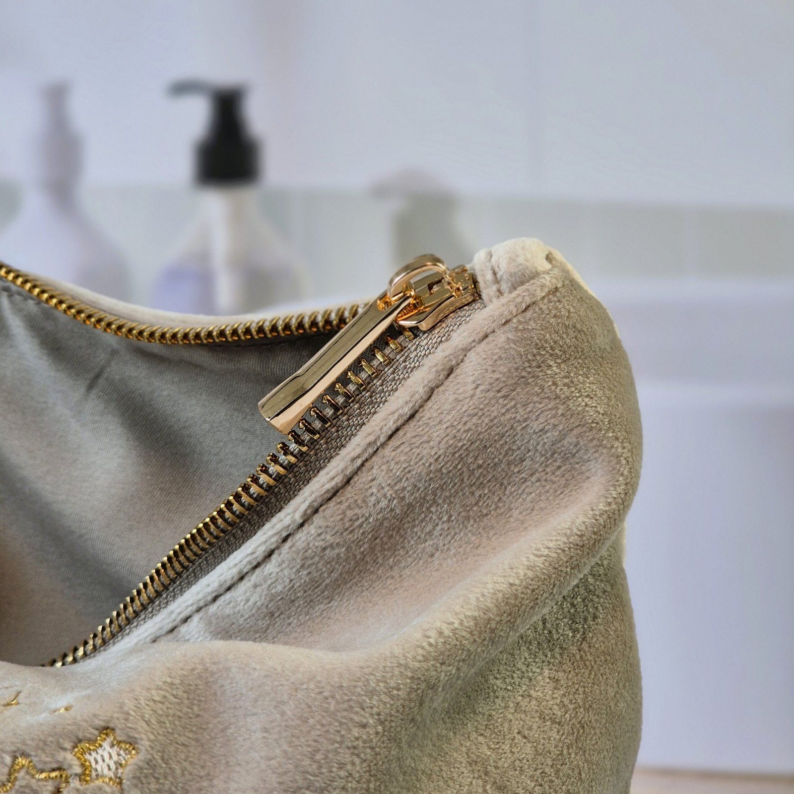 Detail View: Gold and Blue Embroidery on Beige Moonstone Velvet Wash bag Close-up of gold and blue embroidered moon, stars, and evil eye details on Beige Moonstone velvet pouch, Ciel des Rêves collection by Edoaria. Gold Zip.