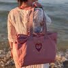 Alexandra, our owner, wearing the Edoaria Everyday tote bag from the Rouge Amour collection with sacred heart and evil eye embroidery
