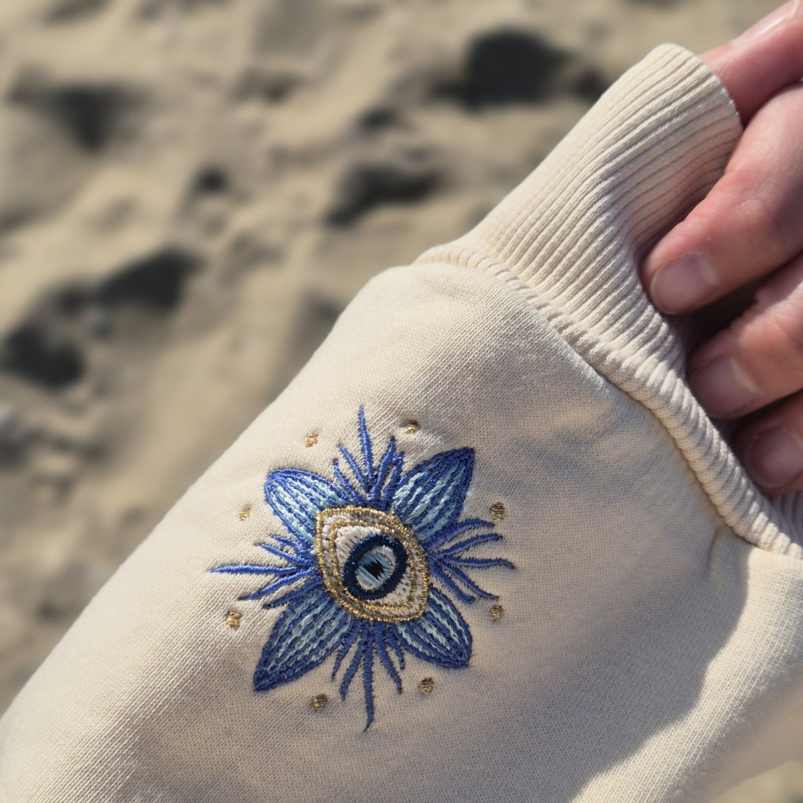 Alexandra, our owner, wearing the Edoaria our mixed cotton embroidered sweatshirt with zipped polo neckline from the Jardin des cyclades collection. Showing the detailed embroidery on the sleeve.